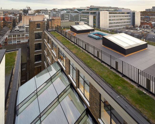Glass atrium with bespoke glazed roof viewed from above with London skyline in the backgorund