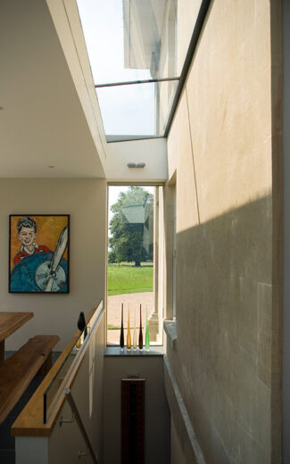 Dining room with Bath stone walls, frameless glass wall and glazed roof