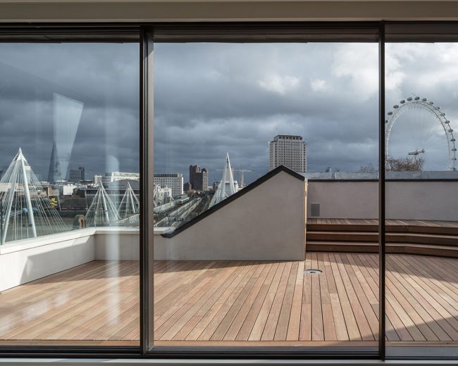 Roof terrace viewed through Sky-Frame sliding doors with London skyline in the background