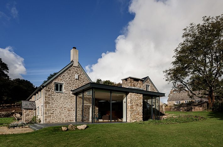 Rural stone house with frameless glass extension and corner opening Sky-Frame doors