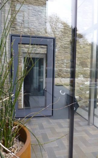 Window suspended within frameless a glass wall