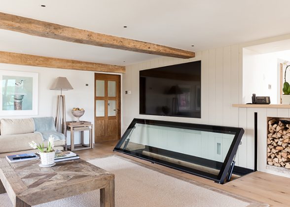 Hinged glass floor open to reveal a stone-walled basement beneath