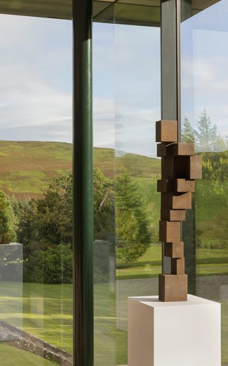 View of rolling green hills through invisible corner glazing